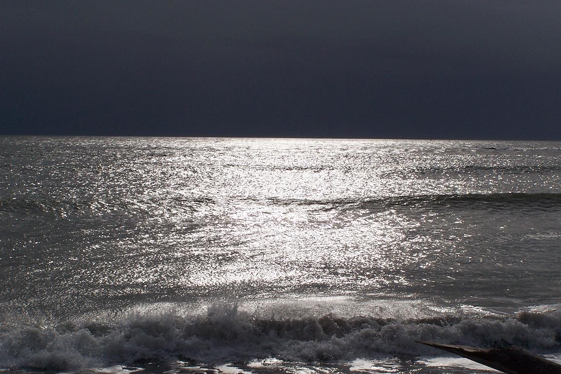 Ocean with little wind and a heavy rain cloud moving in